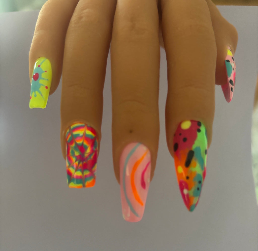 Unhinged colourful mismatched press-on nails worn on a hand